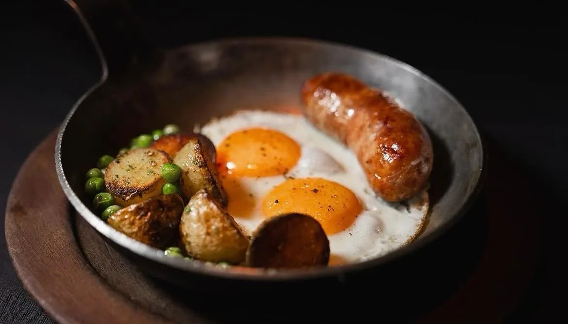 Sartén de hierro con huevos, chorizo casero, papas doradas y arvejas